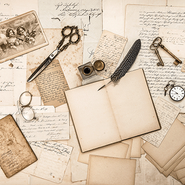 a collection of vintage antique office use items laying on-pages of aged paper