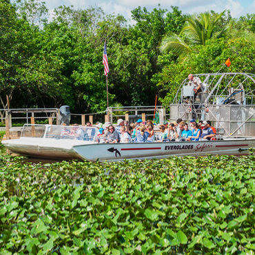 tourists ride fan boat in Florida Everglades